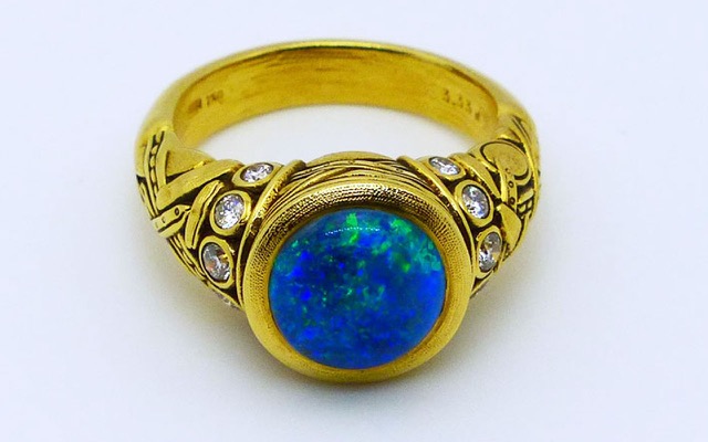 R-58 
“Reed” black opal ring, 18K yellow gold, 3.33 ct black opal center gemstone, 10 side diamonds totaling 0.28 ctw.
Available for immediate delivery in finger size 6 ¾.  
$11,200
