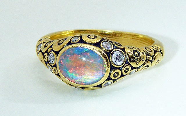 R-79M 
Ring is 18K yellow gold with a 1.17 ct Black Opal center gemstone and 9 diamonds of 0.18 ct total (F-G/VVS).  
Available for immediate delivery in finger size 6 ½. 
$5,160

