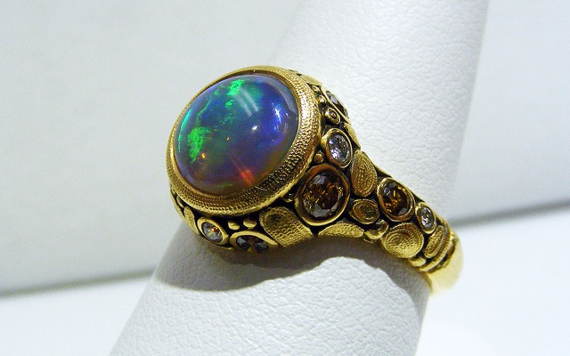 R-84MDDC 
“Circle” ring in 18K yellow gold with a 1.51 ct. black crystal opal from the Lightning Ridge opal fields in Australia. There are also 7 natural colored diamonds totaling 0.11 ct. and 7 white diamonds totaling 0.25 ct., all set in integral bezels. 
Available for immediate delivery in finger size 6 ½  
$10,700

