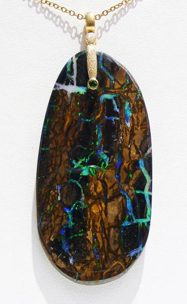 #M-57-MS 
“Sticks & Stones” pendant in 18K yellow gold, featuring a 67.1 ct Matrix Boulder Opal and .04 ct Tsavorite Garnet
$1,514
(Chain not included in price. This item is available in-store.)
